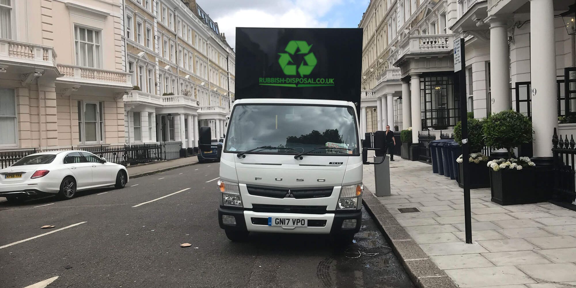 Home-Hero-add-logo Rubbish Disposal white lorry parked outside offices on a typical London street