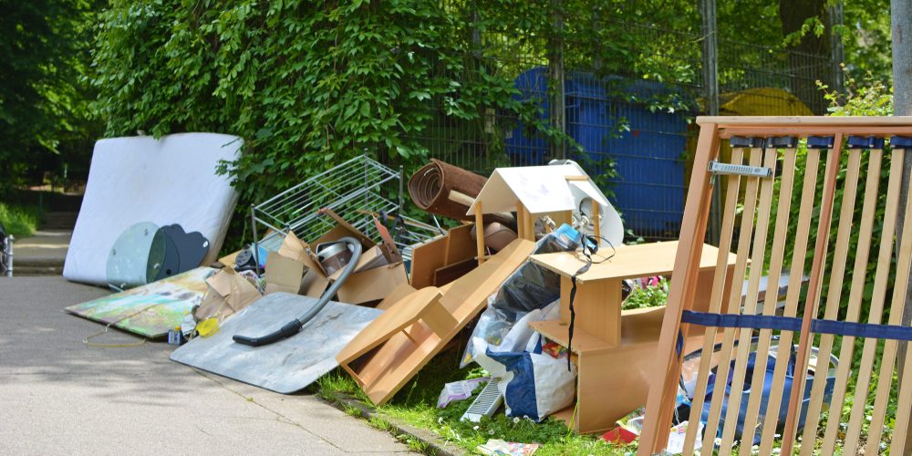 Bulky,Waste,Including,Old,Furniture,,Vacuum,Cleaner,Lying,On,Grass rubbish left on property